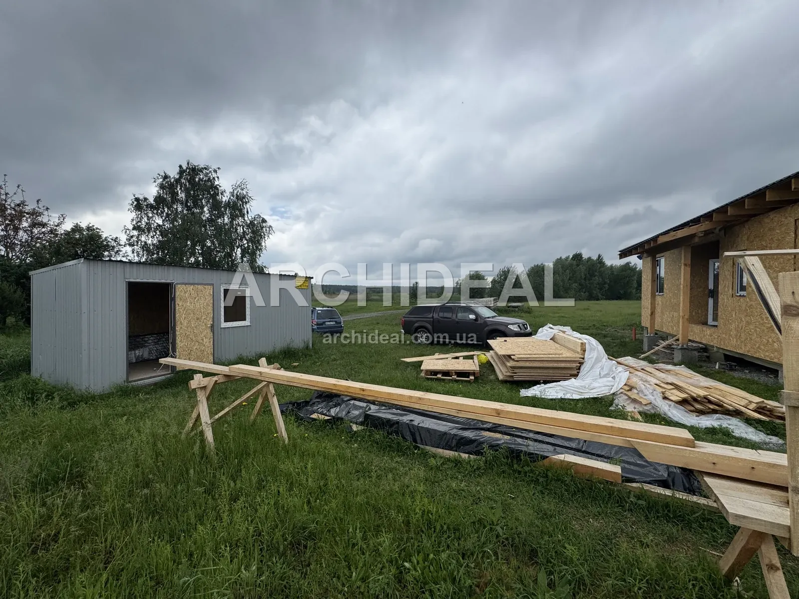 Ділянка з каркасом будинку і складеними дошками