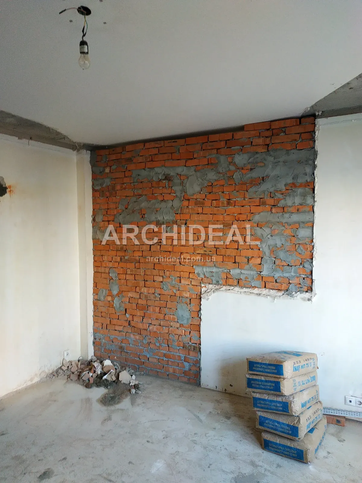 Кімната з оголеною цеглою, будівельне сміття, мішки зі сумішшю