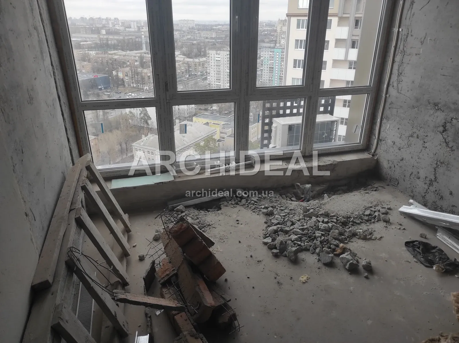 Порожня кімната з розібраною підлогою і видом на місто