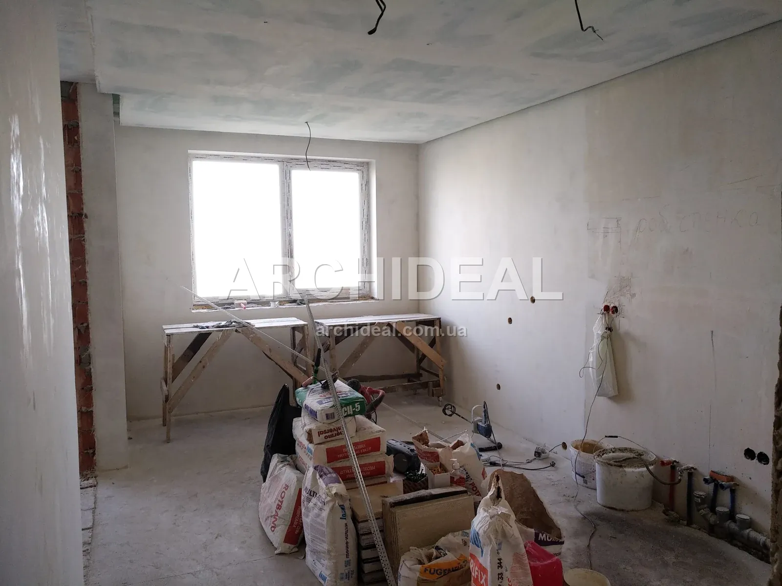 Простора кімната з чорновою електрикою та штукатуркою